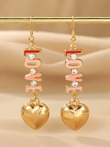 Close-up of gold LOVE earrings with pink and red enamel hearts on a display stand