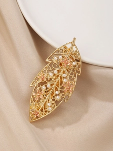 Detail view of golden leaf hair clip with pink enamel flowers and white faux pearls