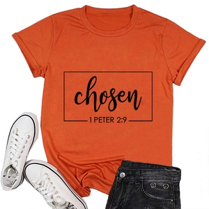 Flat lay of an orange short sleeve T-shirt with black graphic print and Bible verse
