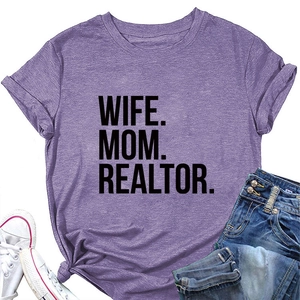 Flat lay of purple short sleeve t-shirt with WIFE MOM REALTOR text and denim shorts