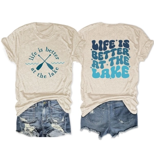 Flat lay of oatmeal T-shirt with lake slogan and ripped denim shorts summer outfit