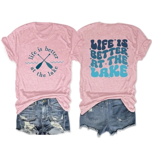 Detail view of pink Life Is Better At The Lake t-shirt with ripped blue denim shorts