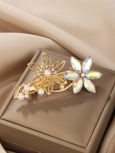 Macro detail of golden flower hair clip with sparkling crystals and elegant pearls