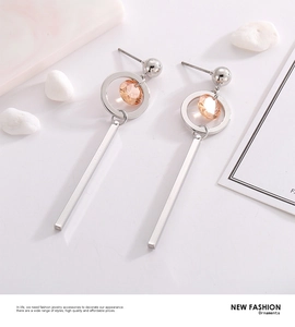 Detail of silver drop earrings with geometric rings and amber multifaceted crystals