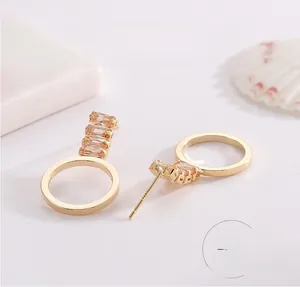 Gros plan du poinçon S925 sur des boucles d'oreilles dorées avec zircons champagne