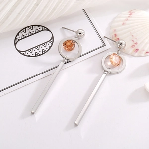Detail view of silver geometric tassel earrings with champagne cubic zirconia stones