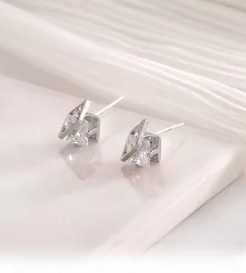Macro shot of geometric square zircon stud earrings with silver hollow frame design