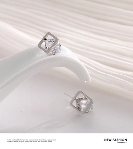 Macro detail of geometric silver square stud earrings with floating cubic zirconia stones