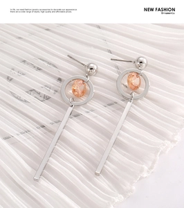Detail of silver drop earrings with amber gemstone and long geometric metal bar