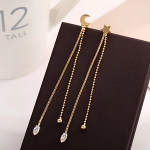 Detail of long gold star and moon tassel earrings with sparkling marquise rhinestones
