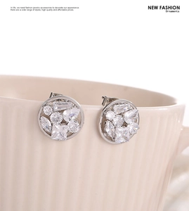 Macro detail of round cluster earrings with cubic zirconia set on a ceramic cup edge