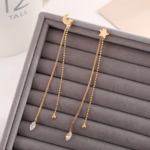 Detail of star and moon tassel earrings with gold chains and crystals in a velvet box