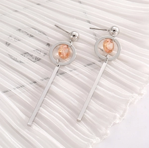 Elegant silver zircon tassel earrings featuring champagne crystals on white fabric