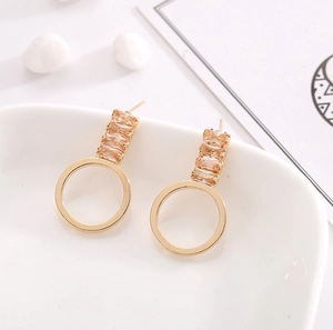 Boucles d'oreilles dorées avec zircons rectangulaires champagne et pendentif circulaire