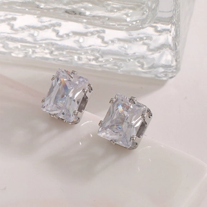 Macro view of rectangular emerald cut zircon stud earrings with silver four-prong setting