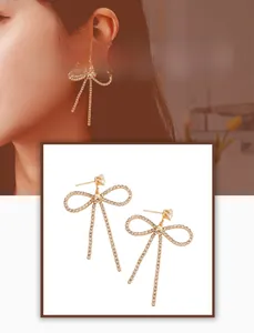 Détail de boucles d'oreilles papillon dorées avec pompons en zircon étincelants pour femme