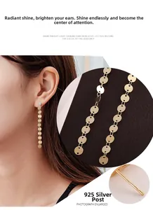 Detail of 925 silver needle on gold tassel earrings with zircon stud and round metal disks
