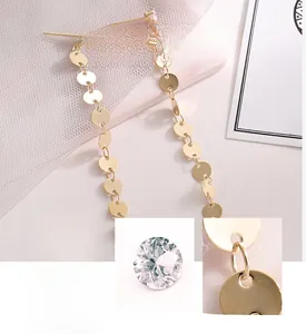 Macro view of gold tassel earrings featuring 3A zircon and polished metallic sequins
