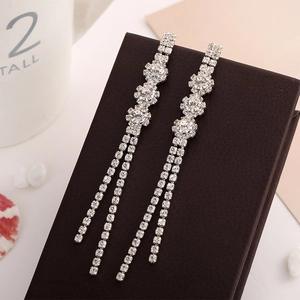 Elegant silver long tassel drop earrings with snowflake floral stud on brown leather