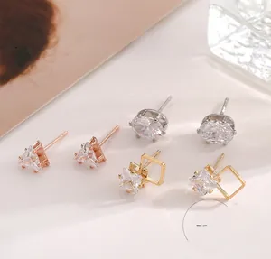 Macro view of geometric stud earrings set featuring cubic zirconia and metallic finishes