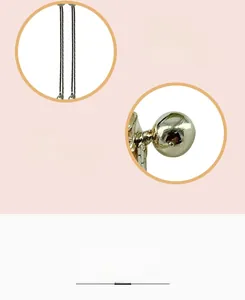 Macro detail of gold plated long tassel earrings showing polished spheres and chain links