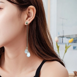 Detailed view of silver long tassel earrings with sparkling teardrop crystal pendants