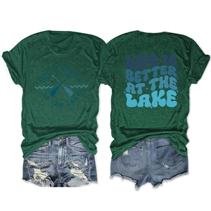 Flat lay of lake-themed green t-shirt with denim shorts showing front and back views