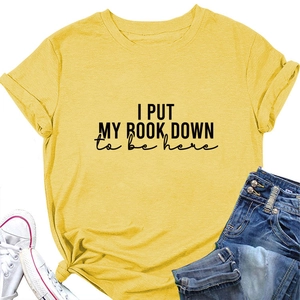 Detail view of cotton yellow T-shirt with 'I PUT MY BOOK DOWN' print and knot detail