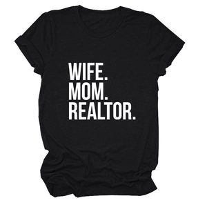 Detail view of WIFE MOM REALTOR bold white typography on a premium black cotton T-shirt
