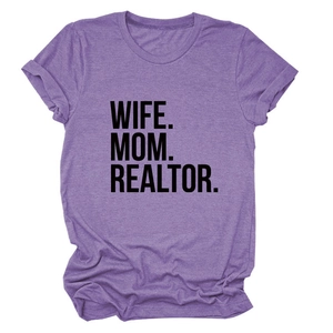 Detailed view of 'WIFE. MOM. REALTOR.' bold black lettering on a purple crew neck cotton t-shirt