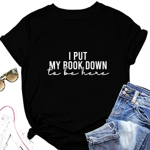 Flat lay of black cotton T-shirt with I PUT MY BOOK DOWN print and denim accessories
