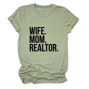 Detail of light green t-shirt featuring bold black WIFE MOM REALTOR text on cotton fabric