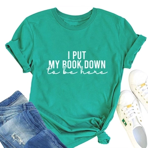 Flat lay of teal cotton T-shirt with 'I PUT MY BOOK DOWN' print and denim jeans