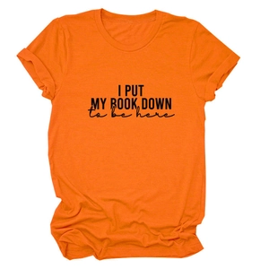 Detail of orange cotton T-shirt featuring 'I PUT MY BOOK DOWN' slogan and rolled sleeves