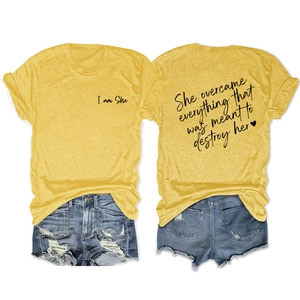 Flat lay detail of yellow T-shirt with I am She print and denim shorts outfit