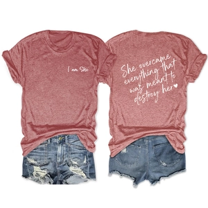 Flat lay of dusty rose T-shirt with white text and distressed denim shorts