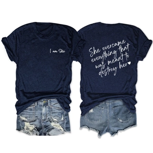 Close-up of navy blue T-shirt with 'She overcame everything' back print and denim shorts