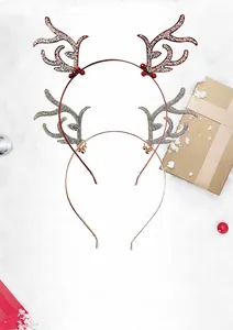 Détail de serre-têtes de Noël en bois de renne avec paillettes, baies et clochettes