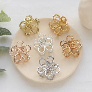 Set aus sechs Mini-Metall-Haarklammern in Gold und Silber auf einem Keramikteller
