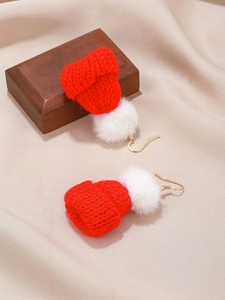 Close-up of red knit Christmas hat earrings with white fuzzy pom-poms and gold hooks