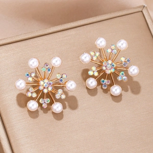 Vue macro de boucles d'oreilles flocon avec perles blanches et cristaux scintillants