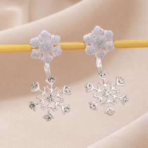 Détail de boucles d'oreilles flocon de neige en argent avec paillettes et cristaux