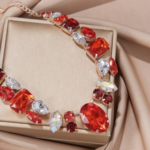 Macro shot of colorful emerald-cut crystals on gold base over champagne silk