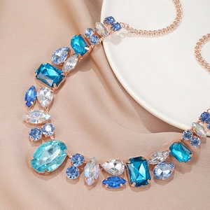 Macro shot of luxury square emerald cut crystals and blue rhinestones on gold necklace