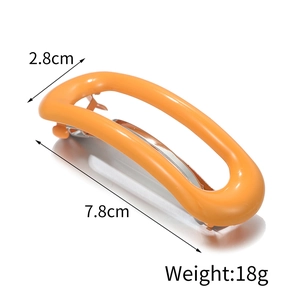 Detailed view of an orange acetate hair clip with dimensions of 7.8cm and 18g weight