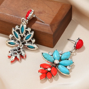 Detailed view of vintage bohemian earrings with turquoise stones and red resin petals
