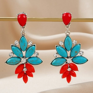 Macro view of bohemian drop earrings with red teardrops and turquoise stones