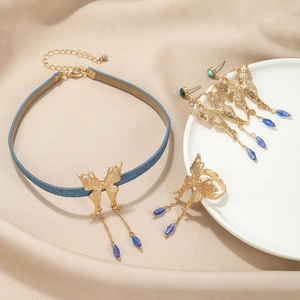 Parure de bijoux papillon dorée élégante avec glands bleus incluant collier, boucles et bague