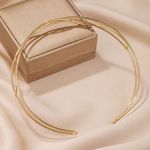 Minimalist double-layered gold U-shape collar necklace on champagne silk background
