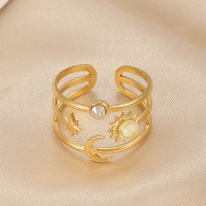 Macro shot of gold plated stainless steel ring featuring celestial sun moon and star motifs